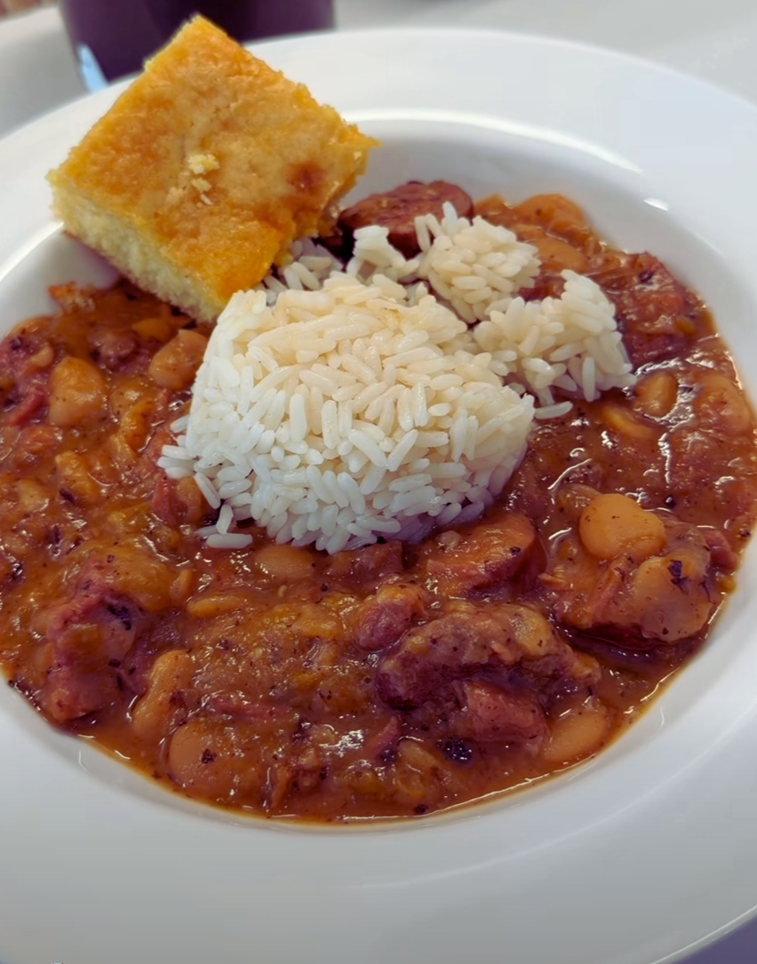 Close-up of creamy red beans and rice with green onions and Cajun seasoning